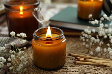 Burning candles and beautiful flowers on table