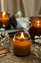 Burning candles and beautiful flowers on table