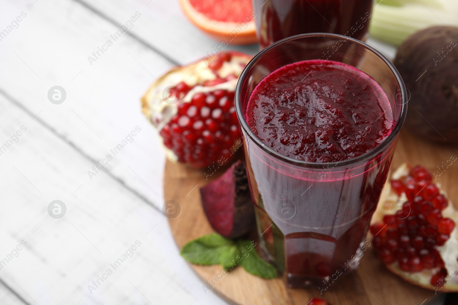 Photo of Fresh beetroot smoothie in glasses on white table, closeup. Space for text