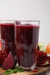 Fresh beetroot smoothie in glasses on table, closeup. Vegan drink