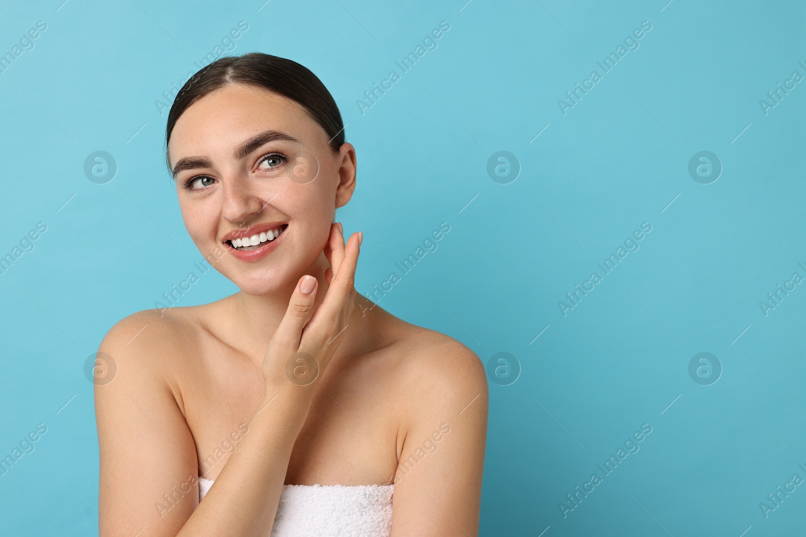 Photo of Beautiful young woman with healthy skin on light blue background, space for text