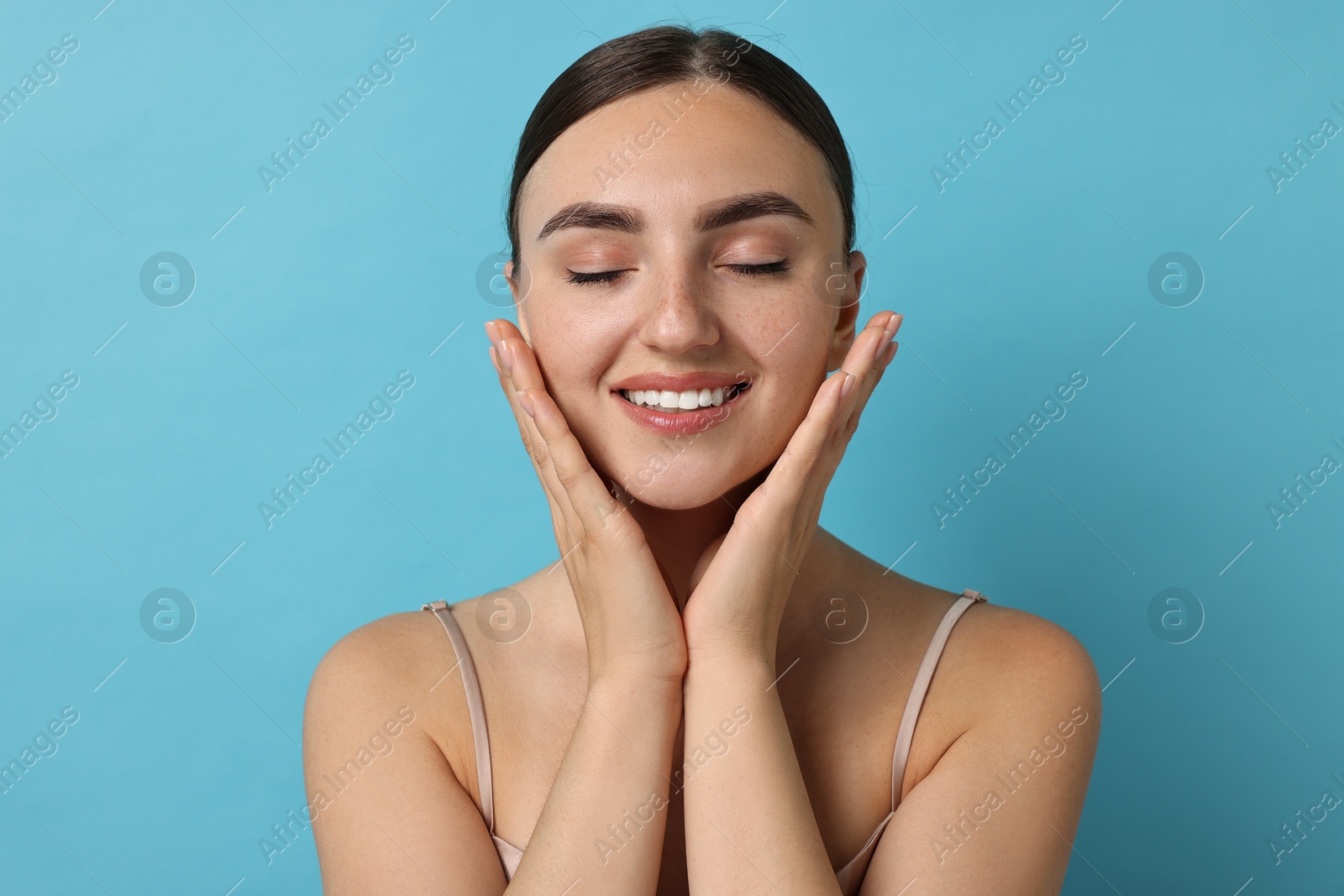 Photo of Beautiful young woman with healthy skin on light blue background