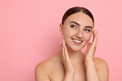 Beautiful young woman with healthy skin on pink background, space for text