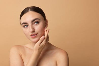 Photo of Face massage. Beautiful young woman with healthy skin on beige background, space for text