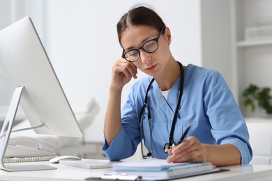 Photo of Nurse taking notes at white table in clinic