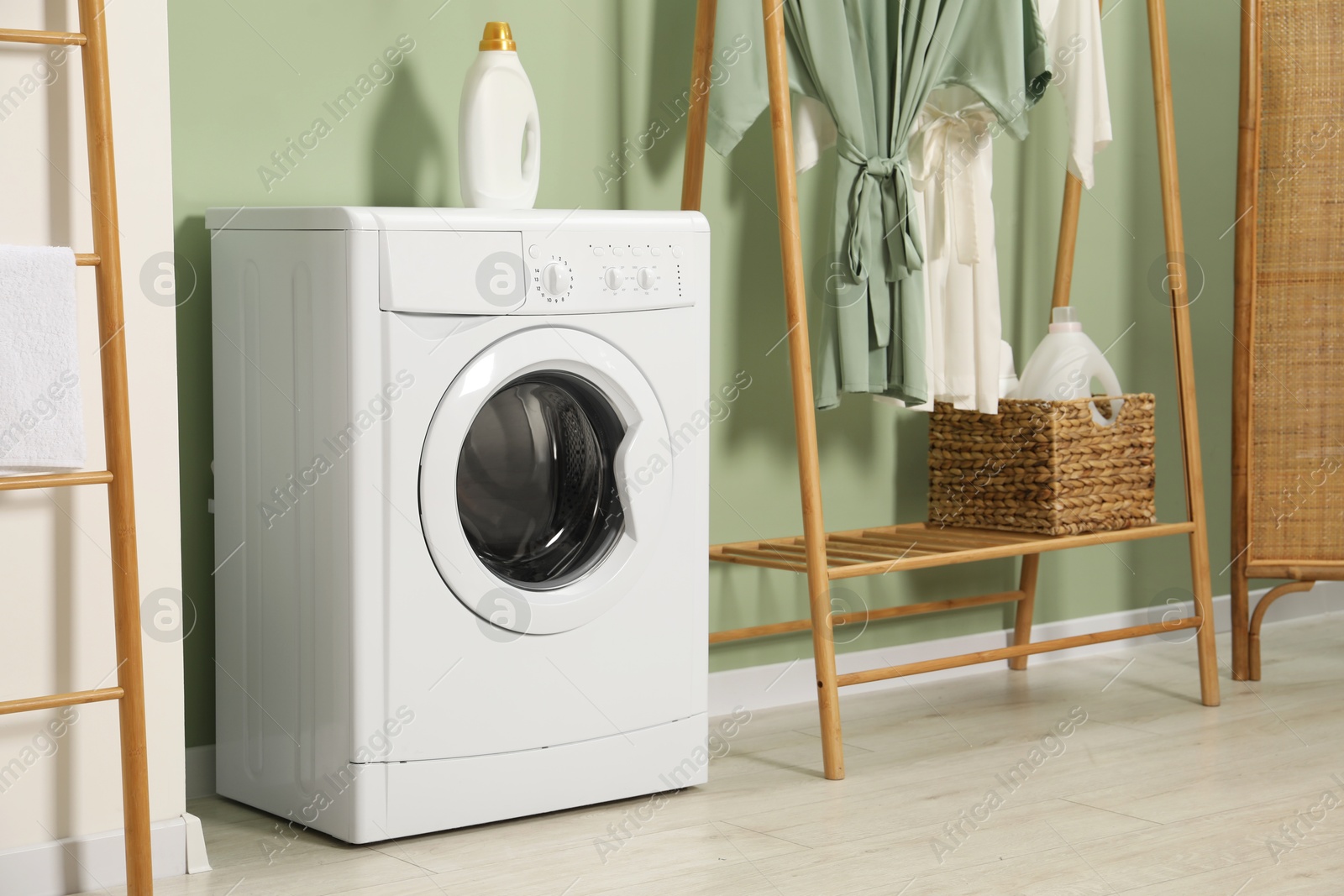 Photo of Washing machine and detergent in laundry room