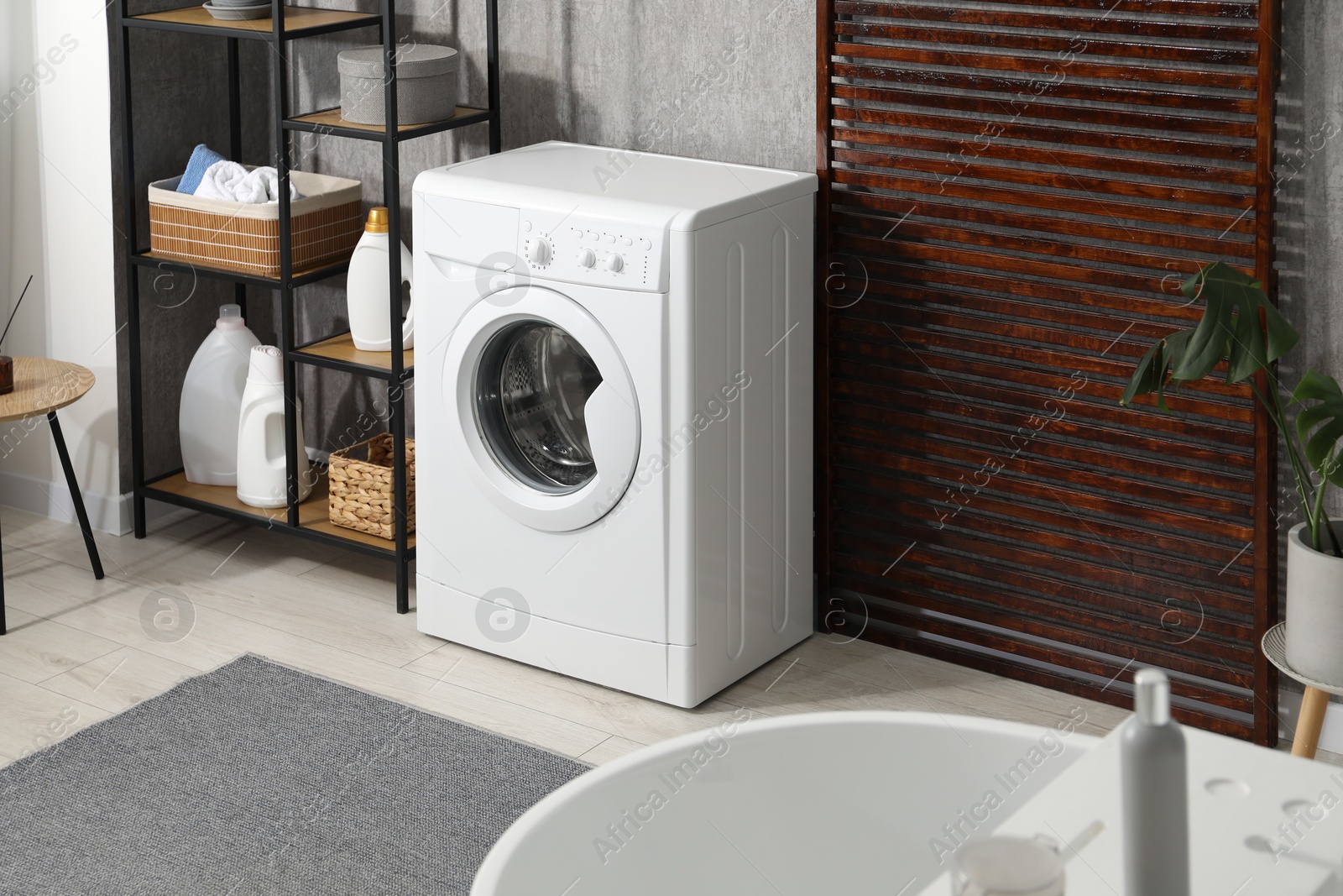 Photo of Washing machine and detergents in laundry room