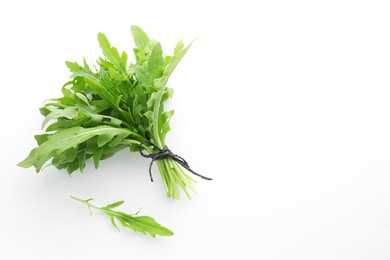 Photo of Fresh green arugula leaves on white background, flat lay. Space for text