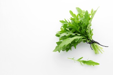 Photo of Fresh green arugula leaves on white background, flat lay. Space for text