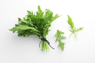 Photo of Fresh green arugula leaves on white background, flat lay