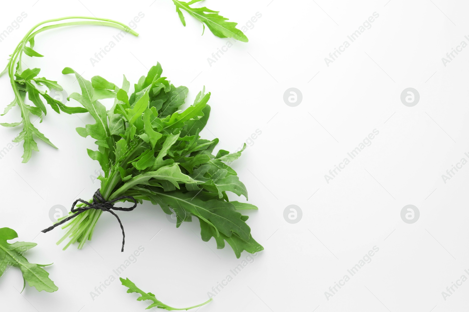 Photo of Fresh green arugula leaves on white background, flat lay. Space for text