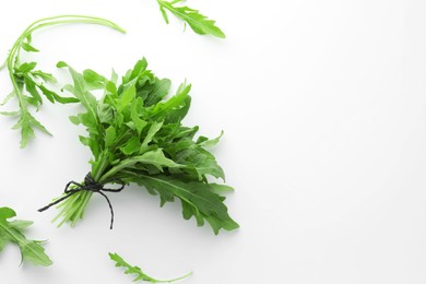 Photo of Fresh green arugula leaves on white background, flat lay. Space for text