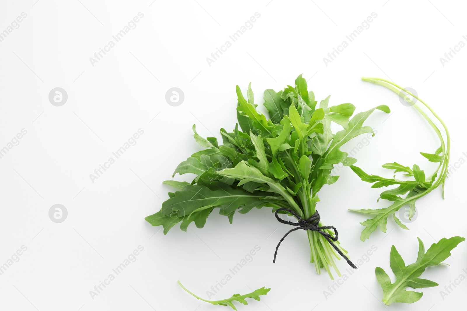 Photo of Fresh green arugula leaves on white background, flat lay. Space for text