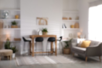 Photo of Blurred view of bar stools near table in room