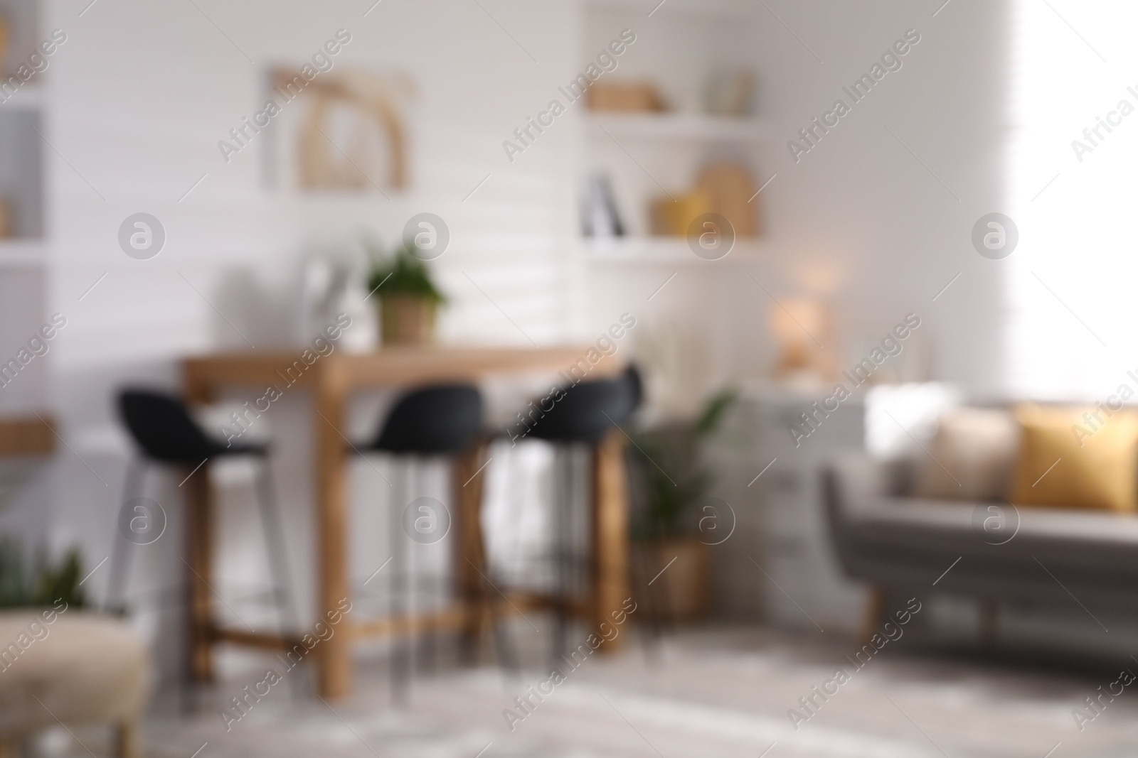 Photo of Blurred view of bar stools near table in room