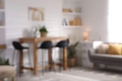 Blurred view of bar stools near table in room