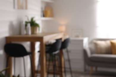 Blurred view of bar stools near table in room