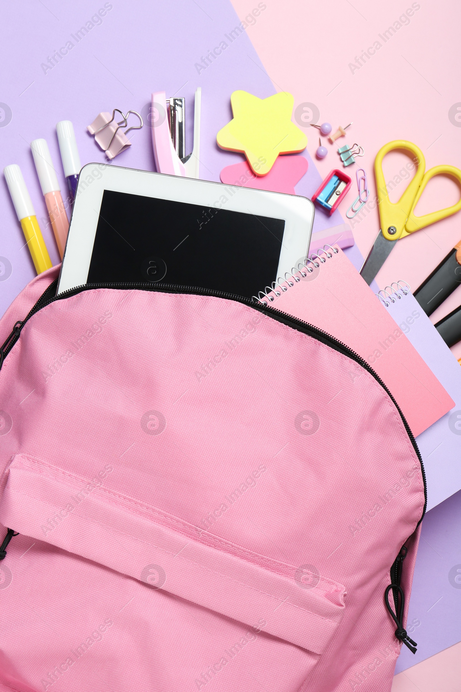 Photo of Backpack and different school stationery on pink background, flat lay