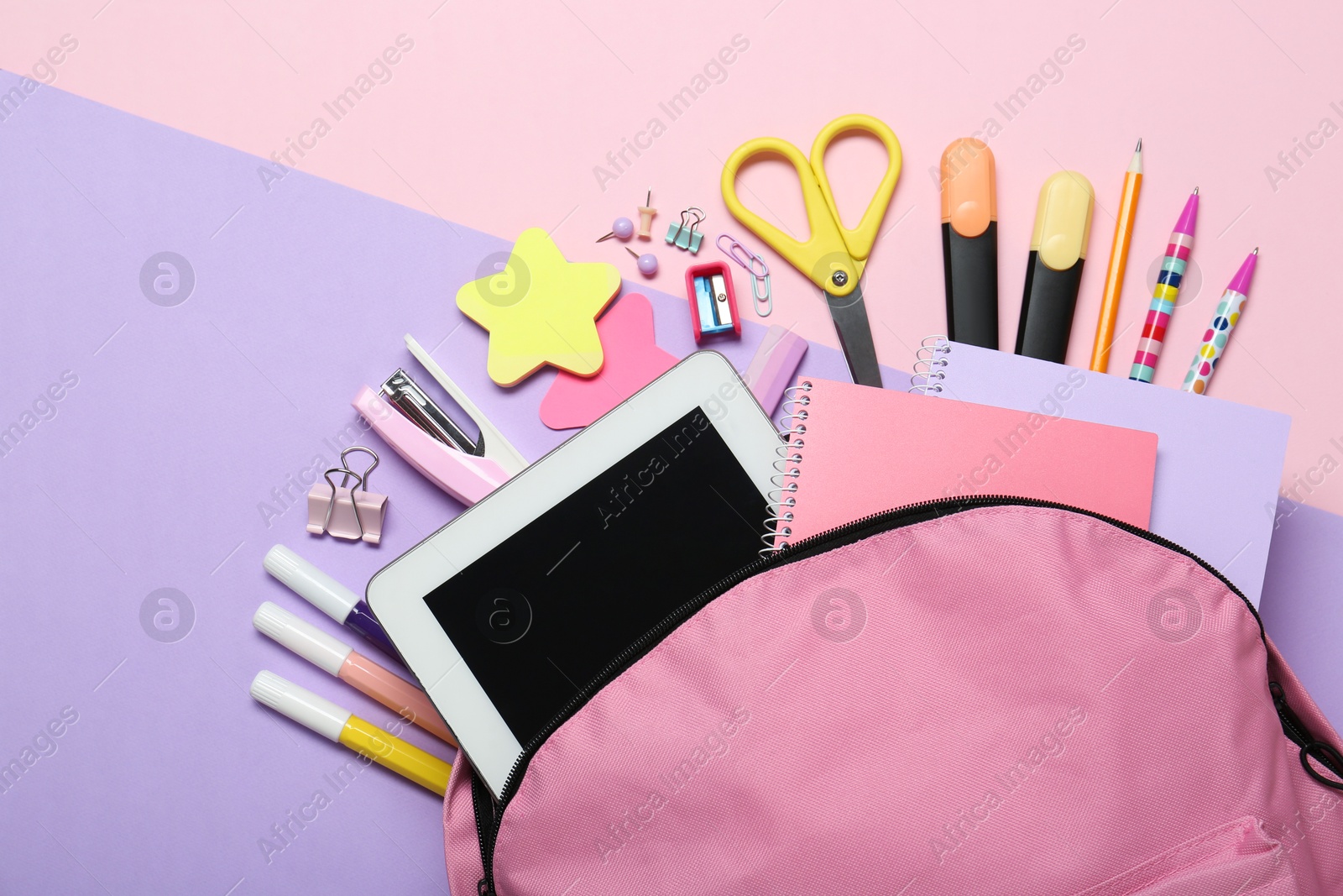 Photo of Backpack and different school stationery on pink background, flat lay