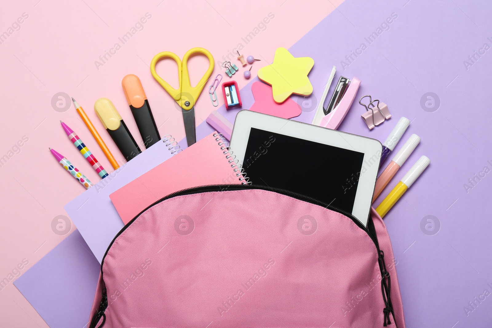 Photo of Backpack and different school stationery on pink background, flat lay