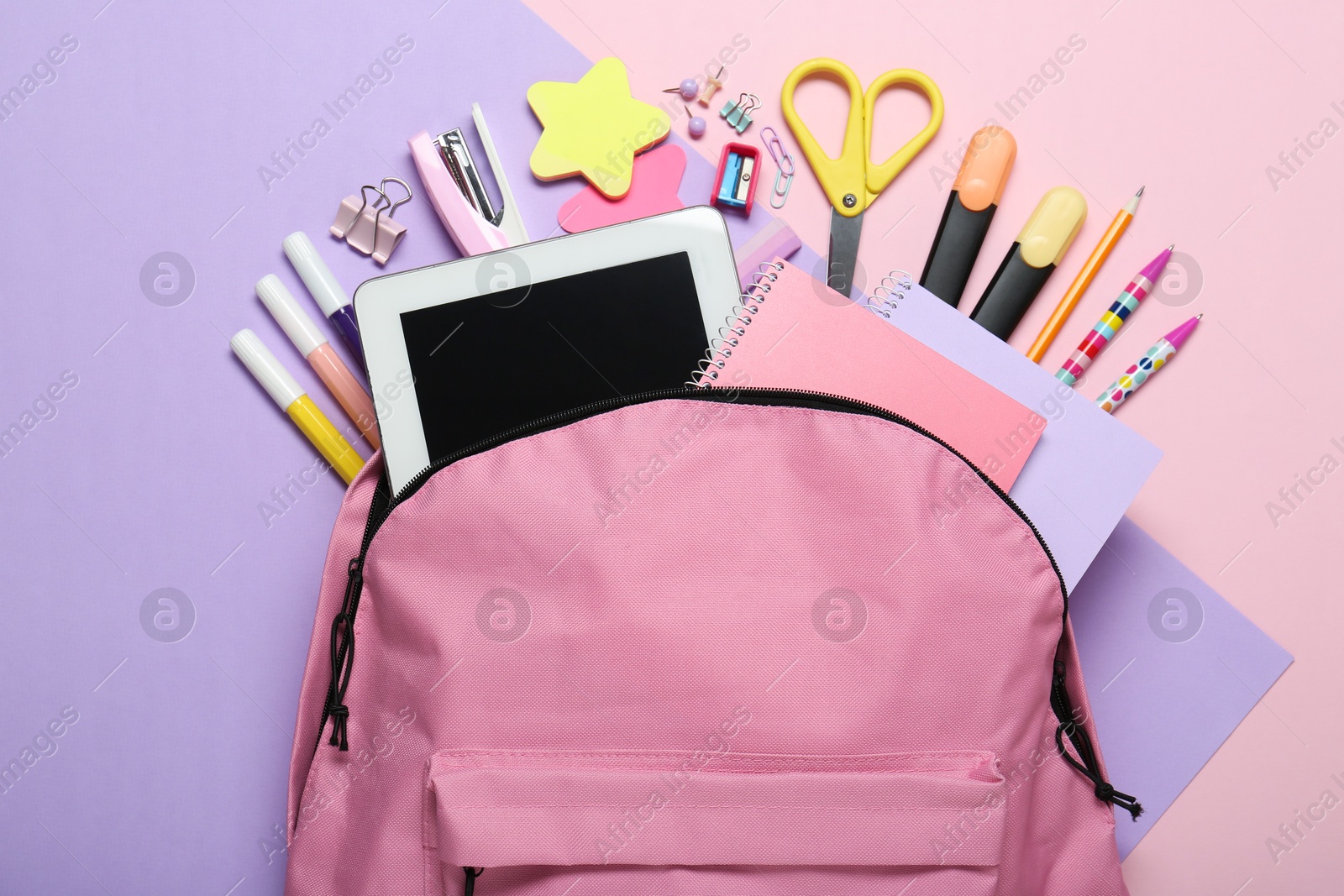 Photo of Backpack and different school stationery on pink background, flat lay