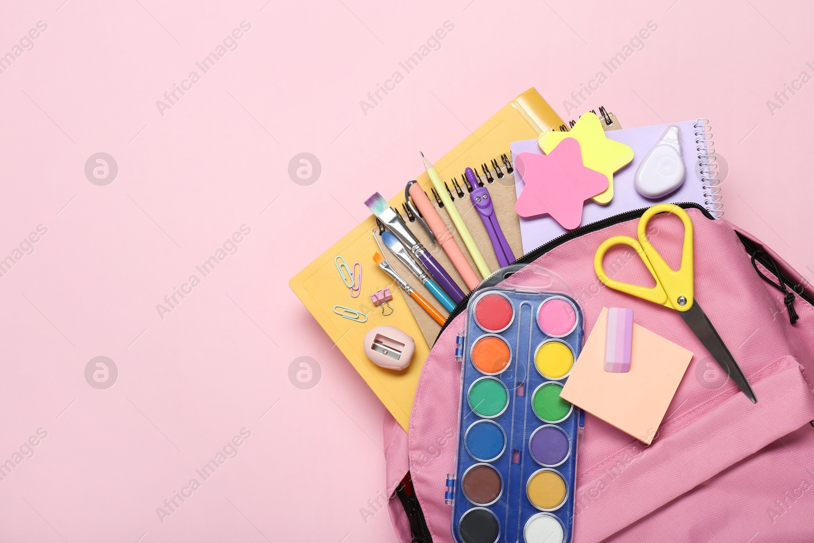 Photo of Backpack and different school stationery on pink background, top view. Space for text