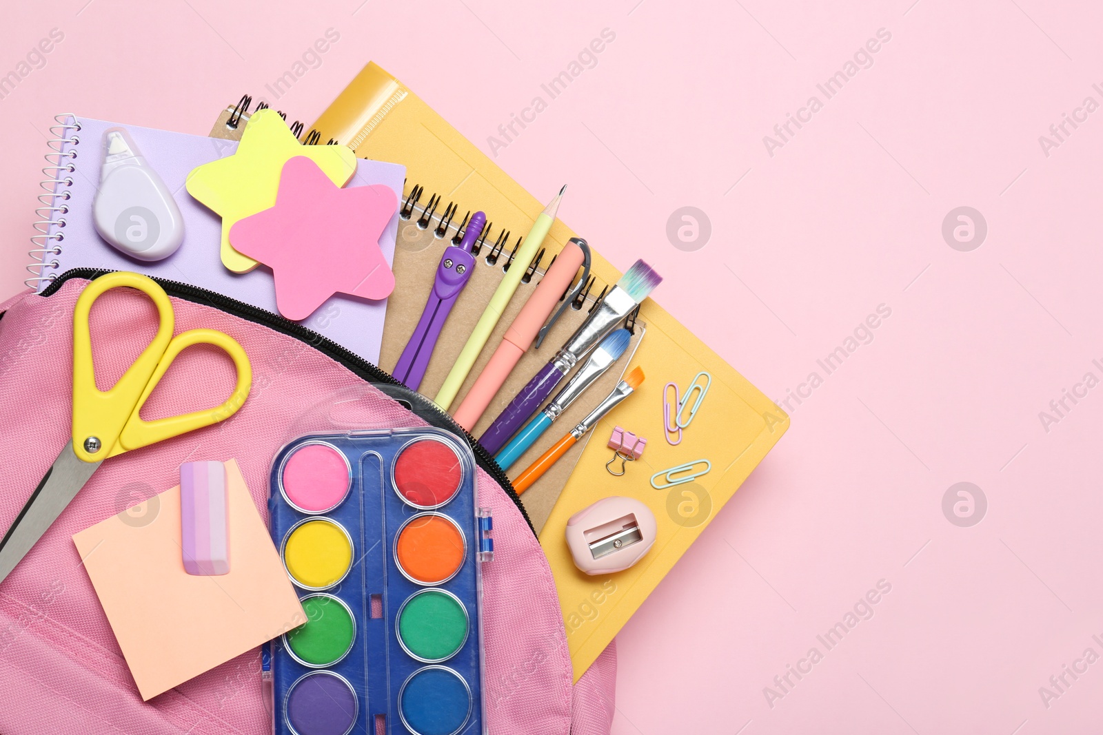 Photo of Backpack and different school stationery on pink background, top view. Space for text