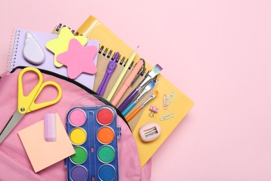 Photo of Backpack and different school stationery on pink background, top view. Space for text