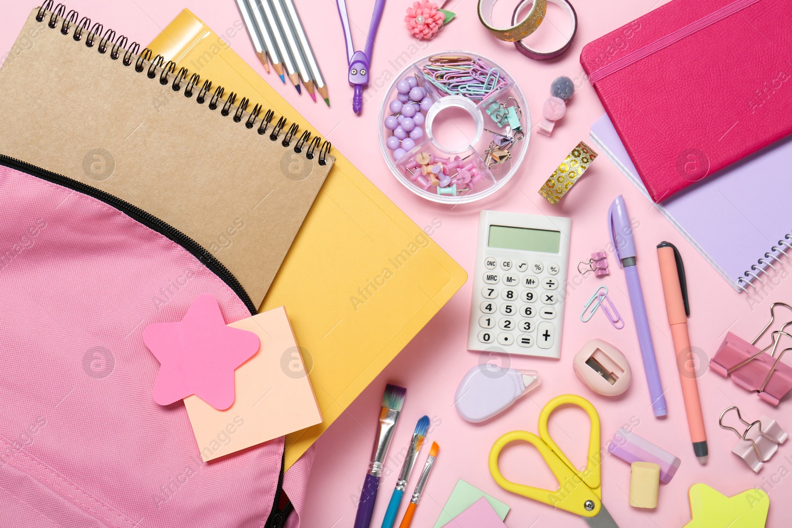 Photo of Backpack and different school stationery on pink background, flat lay