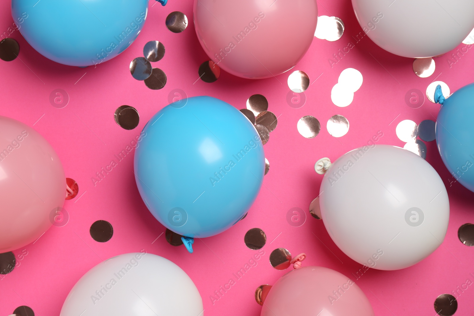 Photo of Shiny golden confetti and air balloons on bright pink background, flat lay