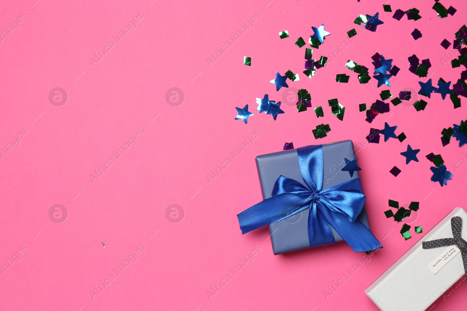 Photo of Shiny confetti and gift boxes on bright pink background, flat lay. Space for text