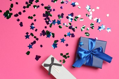 Photo of Shiny confetti and gift boxes on bright pink background, flat lay