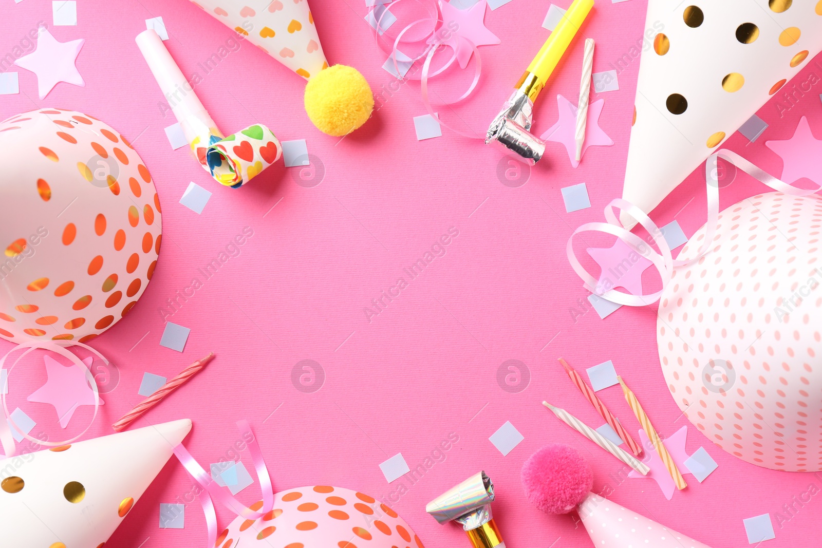 Photo of Frame of party hats, horns, streamers and confetti on pink background, flat lay. Space for text