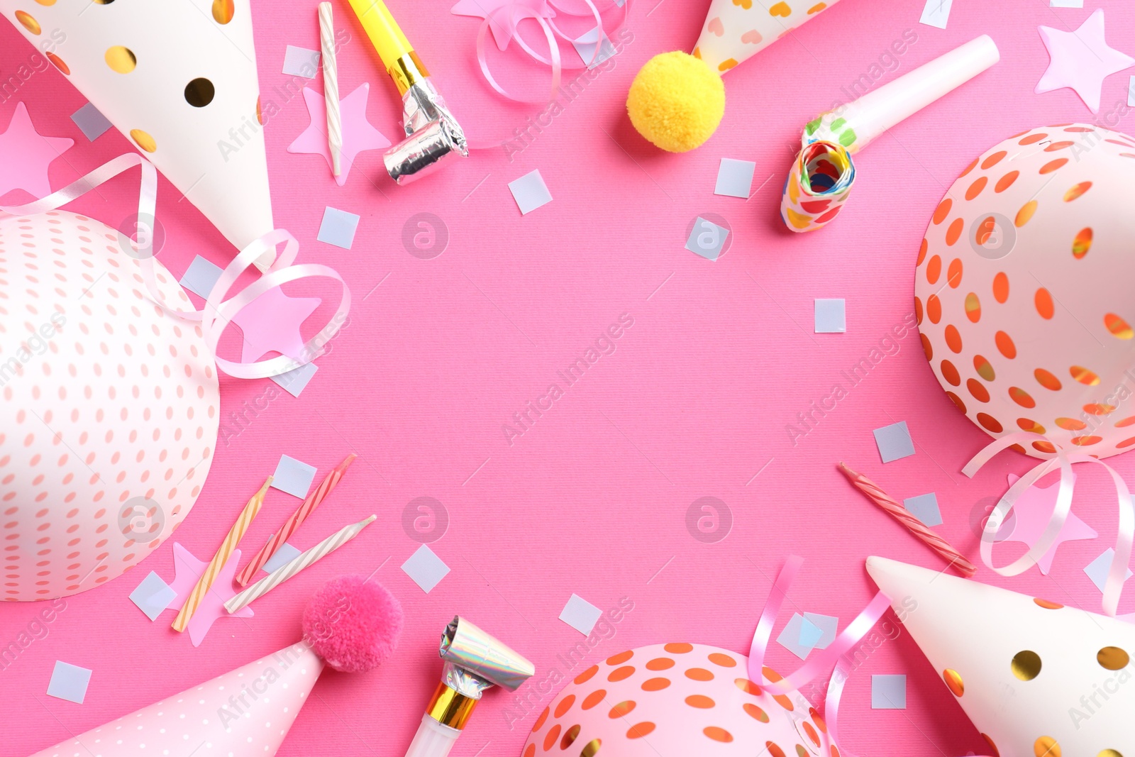 Photo of Frame of party hats, horns, streamers and confetti on pink background, flat lay. Space for text