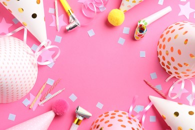 Photo of Frame of party hats, horns, streamers and confetti on pink background, flat lay. Space for text