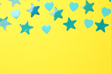 Photo of Beautiful confetti on yellow background, flat lay. Space for text