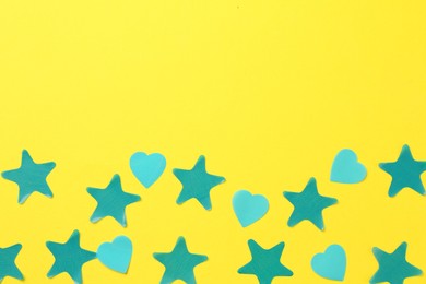 Photo of Beautiful confetti on yellow background, flat lay. Space for text