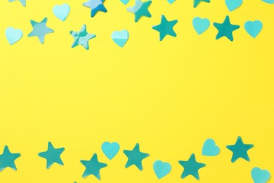 Photo of Beautiful confetti on yellow background, flat lay. Space for text