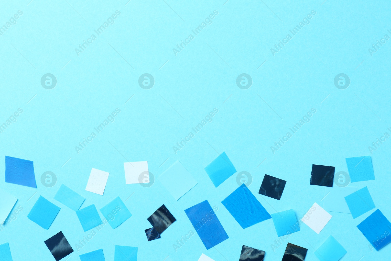 Photo of Beautiful confetti on light blue background, flat lay. Space for text