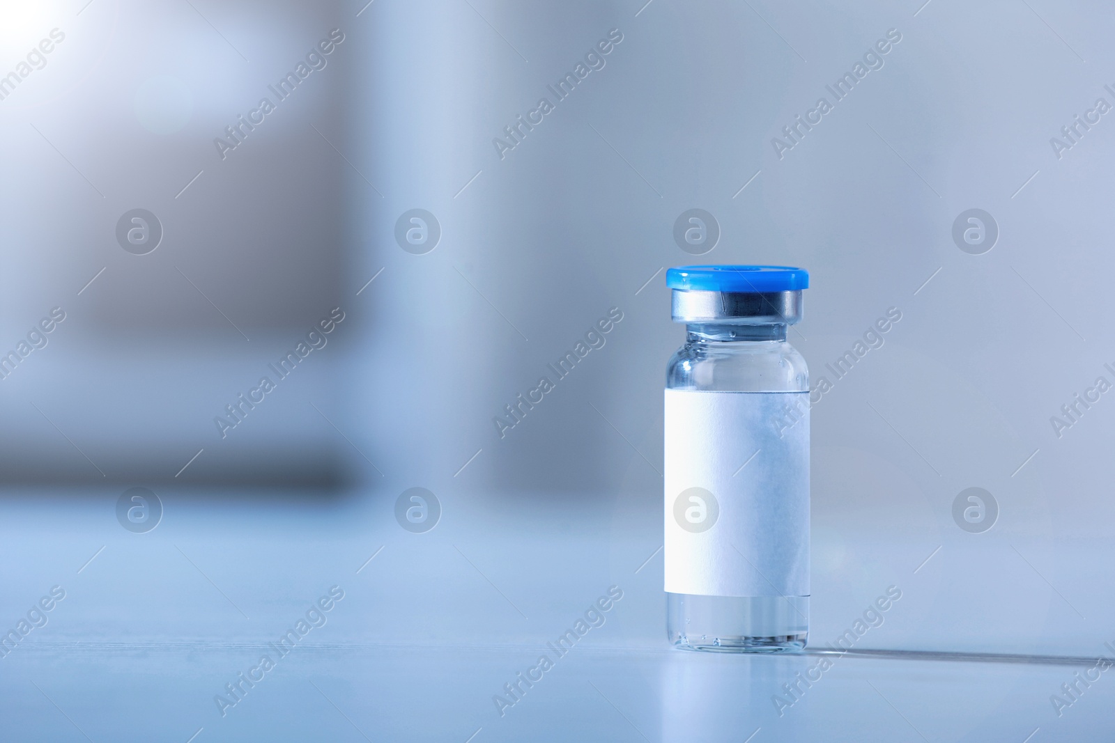 Image of Medication in glass vial on white table, space for text