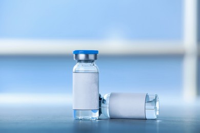 Medication in glass vials with blank labels on table, space for text