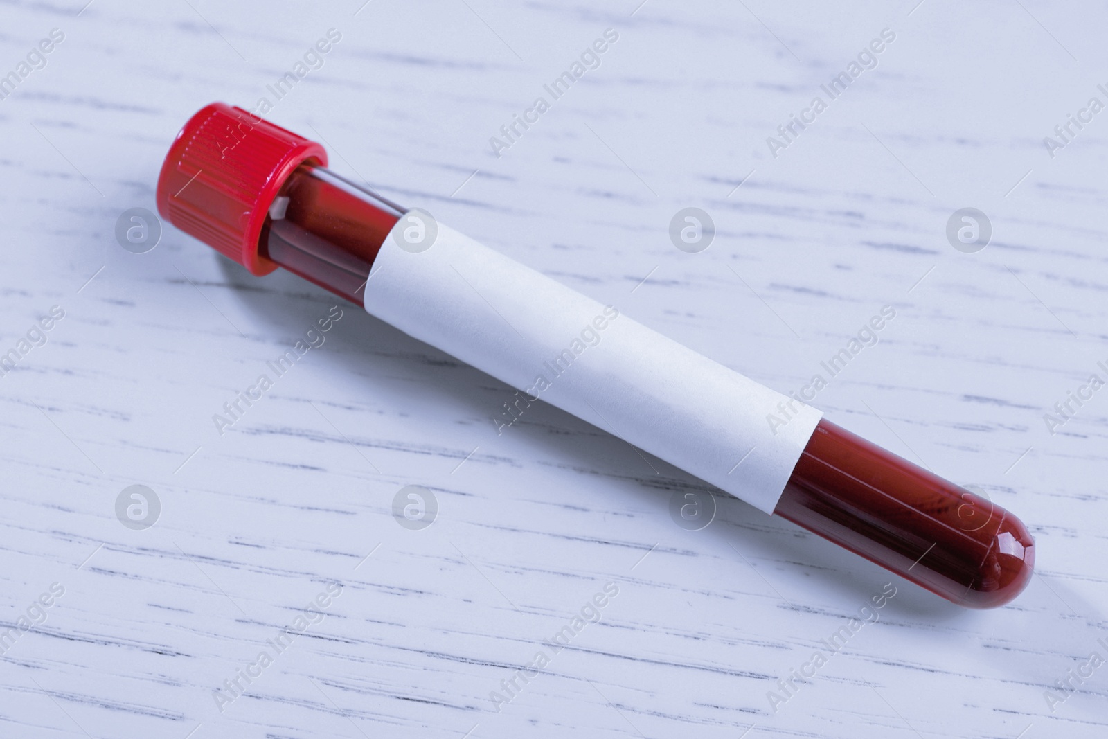 Image of Blood in test tube with blank label on white wooden table, closeup. Laboratory analysis