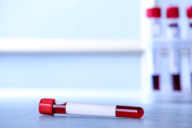 Blood in test tube with blank label on table, space for text. Laboratory analysis