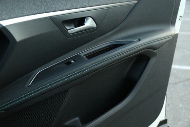 Photo of Closeup view of black car door inside modern automobile