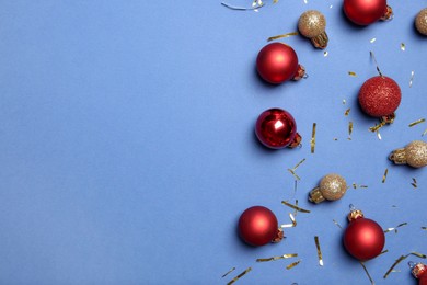 Photo of Flat lay composition with Christmas balls on blue background, space for text