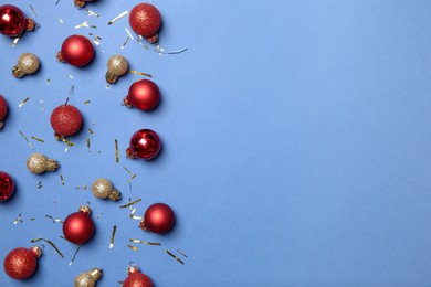 Photo of Flat lay composition with Christmas balls on blue background, space for text