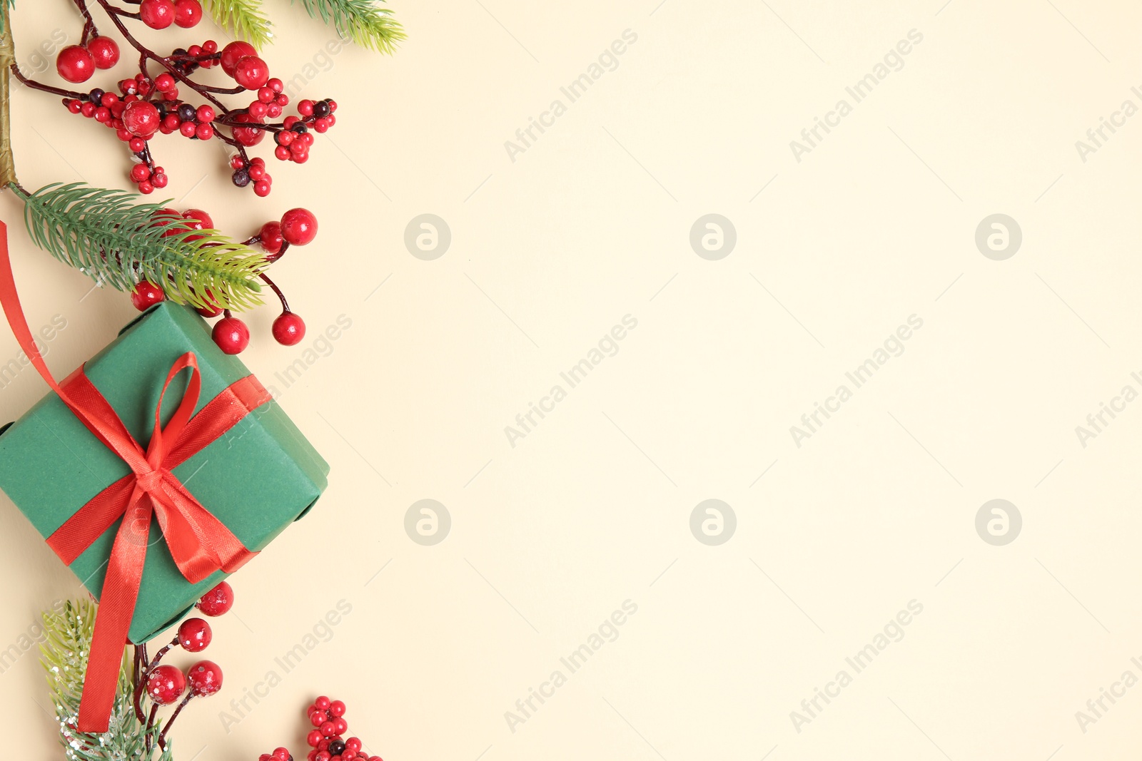 Photo of Flat lay composition with Christmas decor and gift box on beige background. Space for text