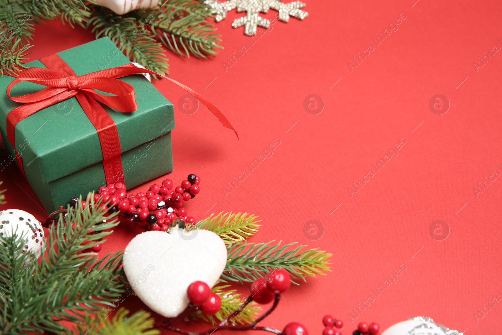 Photo of Christmas decor and gift box on red background, closeup. Space for text