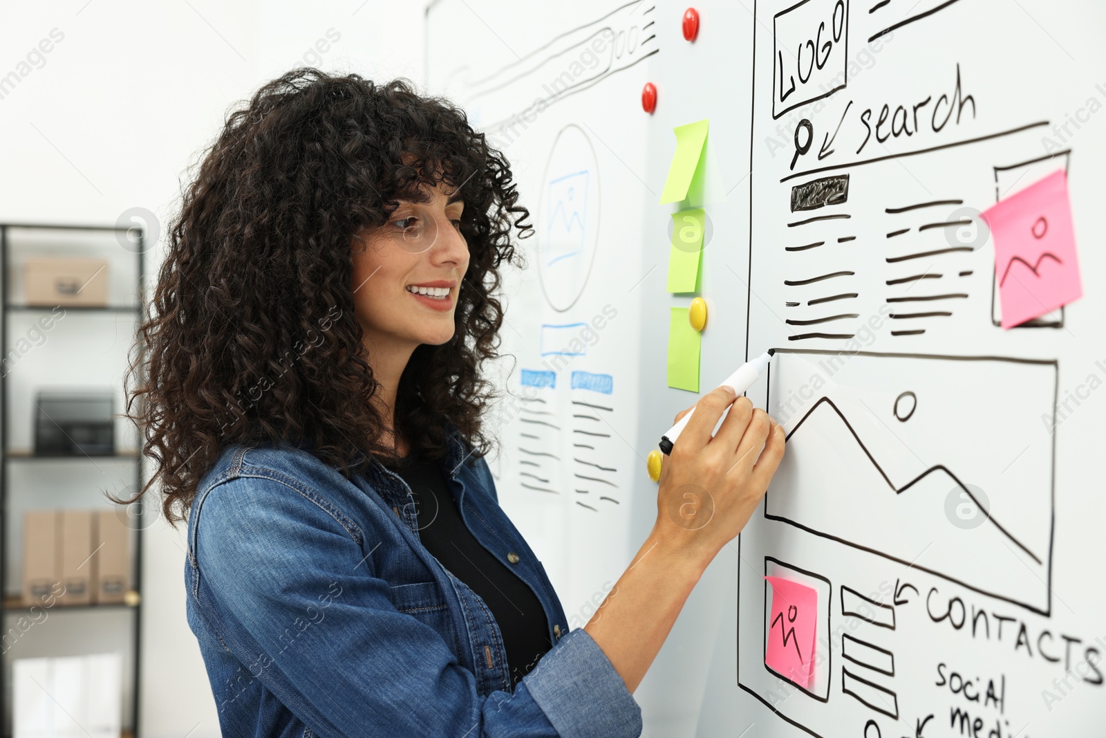 Photo of Developing UI design. Woman drawing website wireframe on whiteboard indoors