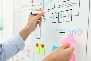 Developing UI design. Man drawing website wireframe on whiteboard indoors, closeup